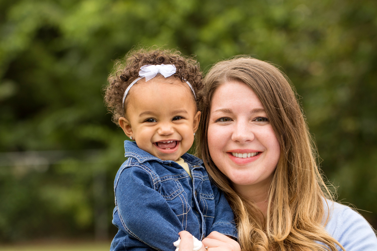 Adorable little girl laughing. Mixed family.  Portrait of a Caucasian mother and bi-racial daughter.